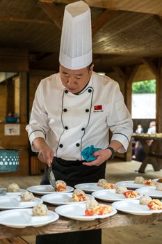 Sibiu City, Romania - 23 June 2019. Chinese cook arranges food on plates at the premiere of Lantern Festival from Astra museum in the Sibiu International Theatre Festival from Sibiu, Romania