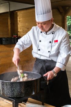 Sibiu City, Romania - 23 June 2019. Chinese cook arranges food on plates at the premiere of Lantern Festival from Astra museum in the Sibiu International Theatre Festival from Sibiu, Romania