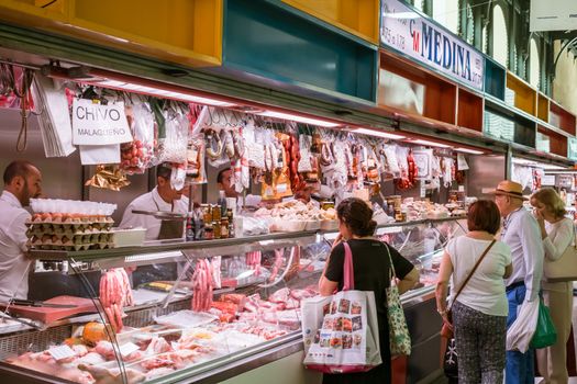 Malaga, Spain - May 06, 2018. Customers at the Spanish specialties fom Ataranzanas Central Market, Malaga, Spain