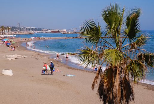 Marbella, Spain - June 27, 2018. Holidaymakers sunbathing on Venus beach, Marbella city and resort area, province of Malaga, Andalucia region, Spain, Western Europe.