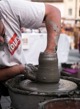 Sibiu City, Romania - 31 August 2019. Hands of a potter shaping a clay pot on a potter's wheel at the potters fair from Sibiu, Romania