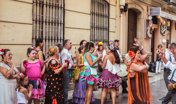 Malaga, Spain - August 12, 2018. People having fun on the street at the Feria de Malaga, an annual event that takes place in mid-August and is one of the largest fiestas in Spain