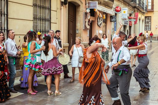 Malaga, Spain - August 12, 2018. People having fun on the street at the Feria de Malaga, an annual event that takes place in mid-August and is one of the largest fiestas in Spain