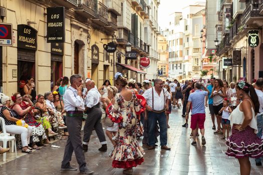 Malaga, Spain - August 12, 2018. People having fun on the street at the Feria de Malaga, an annual event that takes place in mid-August and is one of the largest fiestas in Spain
