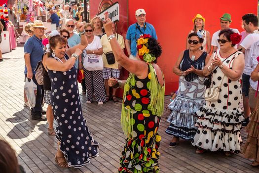 Malaga, Spain - August 18, 2018. People having fun on the street at the Feria de Malaga, an annual event that takes place in mid-August and is one of the largest fiestas in Spain