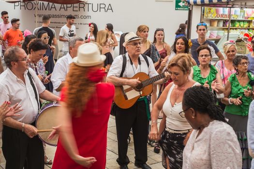 Malaga, Spain - August 17, 2018. People having fun on the street at the Feria de Malaga, an annual event that takes place in mid-August and is one of the largest fiestas in Spain