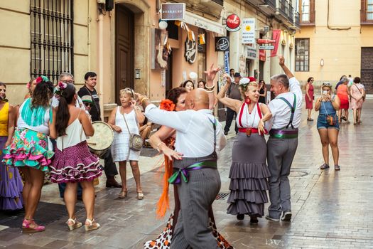Malaga, Spain - August 12, 2018. People having fun on the street at the Feria de Malaga, an annual event that takes place in mid-August and is one of the largest fiestas in Spain