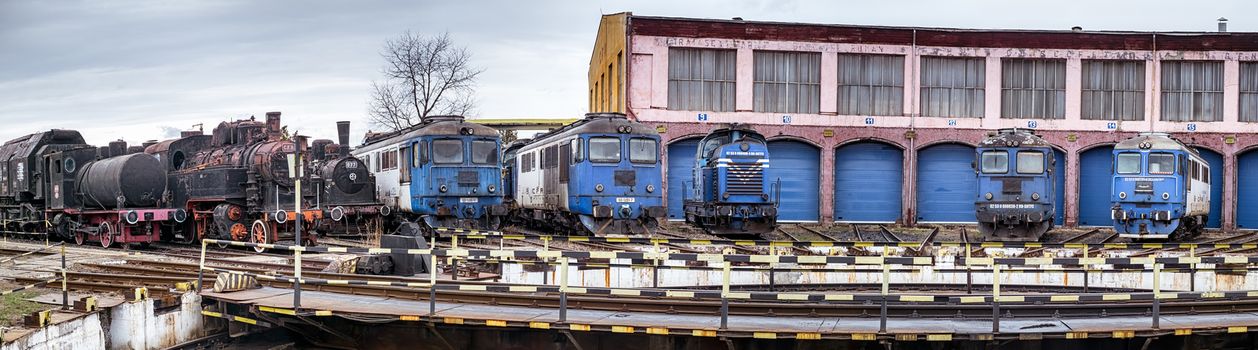 Sibiu, Romania - March 16, 2019. Railway depot with old steam and modern diesel locomotives