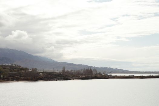 Beautiful mountain landscape. The shore of Lake Issyk-Kul. Wildlife of Kyrgyzstan. Clouds in the sky. High quality photo