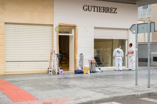 Malaga, Spain - March 10, 2018. Workers working on exterior shop design.