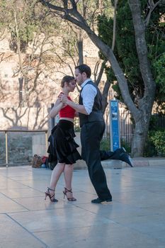 Malaga, Spain - May 12, 2018. Young Couple Dancing in front of Roman theater Alcazaba, Malaga city, Spain