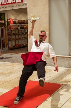 Malaga, Spain - August 03, 2018. This is a human sculpture featuring a waiter falling down on the Marques de Larios pedestrian, in the historic center of Malaga, Spain