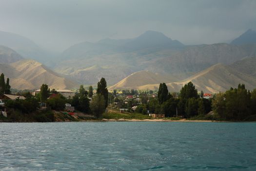 Beautiful mountain landscape. The shore of Lake Issyk-Kul. Wildlife of Kyrgyzstan. Clouds in the sky. High quality photo