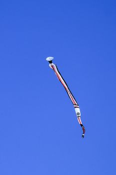 kite long tailfly on blue sky. The colorful kite on the blue sky without clouds. Space for text.