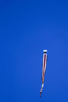 kite long tailfly on blue sky. The colorful kite on the blue sky without clouds. Space for text.