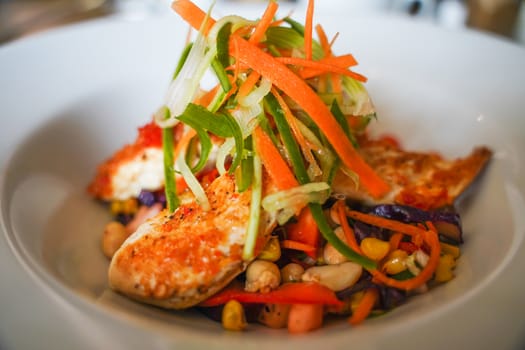 A close-up of a chicken salad in a white bowl