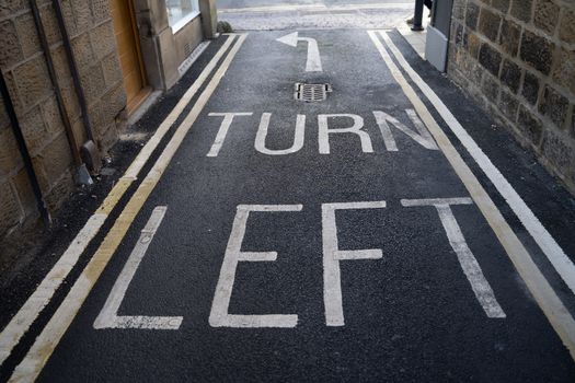 A Turn Left Arrow painted on the the tarmac in the UK