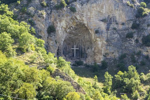 cross placed in a niche on a mountain in the town of rocca porena