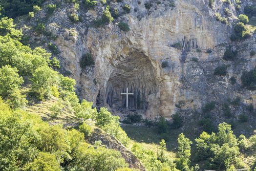 cross placed in a niche on a mountain in the town of rocca porena