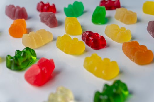 Pile of multicolored jelly bears candy on a white background.