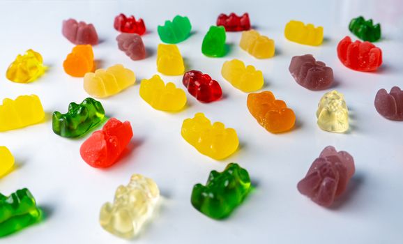 Pile of multicolored jelly bears candy on a white background.