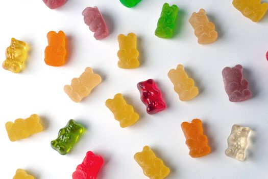 Pile of multicolored jelly bears candy on a white background.