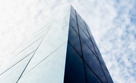 wall of a modern building against the sky and clouds abstract architectural background