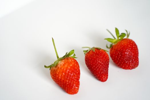 Three strawberries against a plain white background