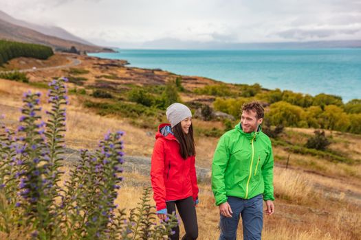 New Zealand travel - couple tourists hiking in nature with view of Lake Pukaki near Aoraki aka Mount Cook at Peter's lookout, a famous tourist destination on New Zealand.