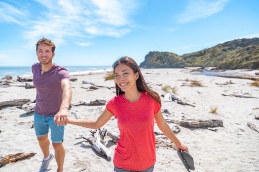 Couple walking on beach in New Zealand - people in Ship Creek on West Coast of New Zealand. Tourist couple sightseeing tramping on South Island of New Zealand.