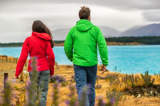 New Zealand travel - couple tourists looking at nature view of Lake Pukaki hiking near Aoraki aka Mount Cook at Peter's lookout, a famous tourist destination.