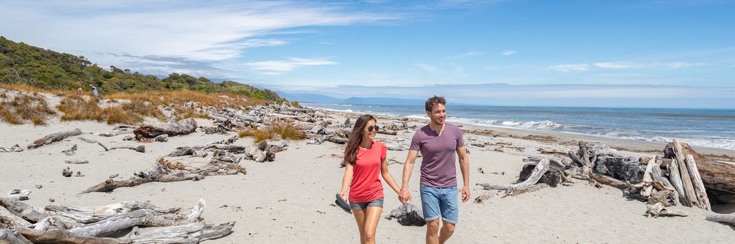 Panoramic banner of Couple walking on beach in New Zealand - people in Ship Creek on West Coast of New Zealand. Tourist couple sightseeing tramping on South Island of New Zealand.