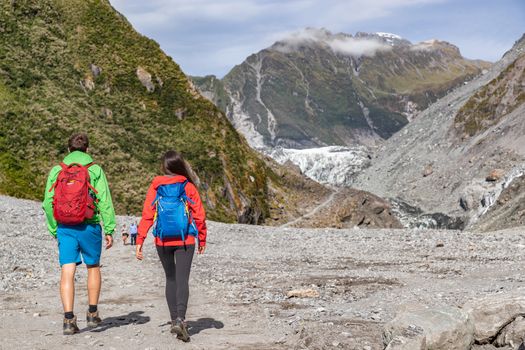 New Zealand tourists backpacking in nature landscape by Franz Josef Glacier, Westland Tai Poutini National Park, South Island, New Zealand. Couple on travel arriving at famous viewpoint.