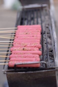 Pink hotdog Skewers Is being roasted on an electric stove for sale