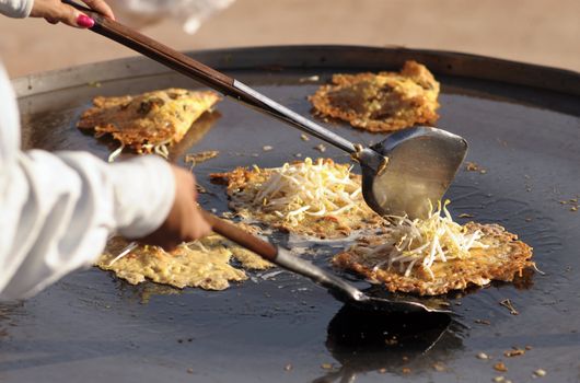 Crisp Fried Mussels Pancake Thai food on a large iron pan.