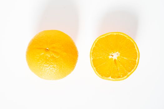 A whole orange and a half against a plain white background