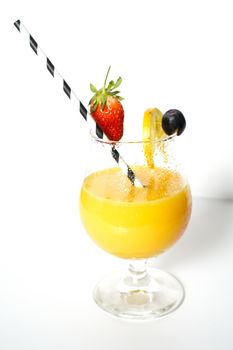 An orange cocktail drink with a party straw against a plain white background