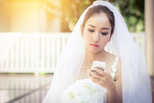 bride talking on cell phone in wedding dress