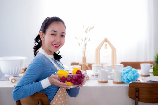 Pretty female holding bowl with a smile in kitchen