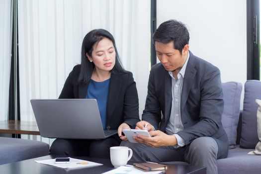 Team of business two people working together on a laptop with during a meeting sitting around a table.