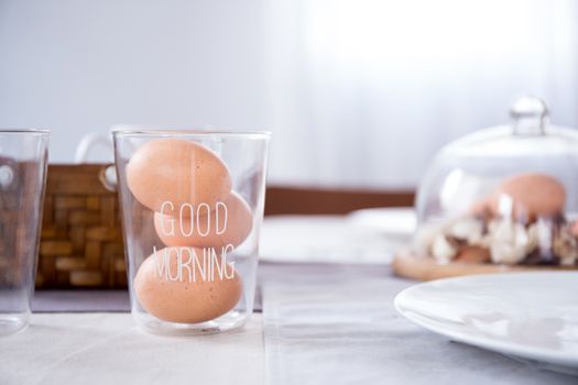 egg in glass with good morning text on table in the kitchen.