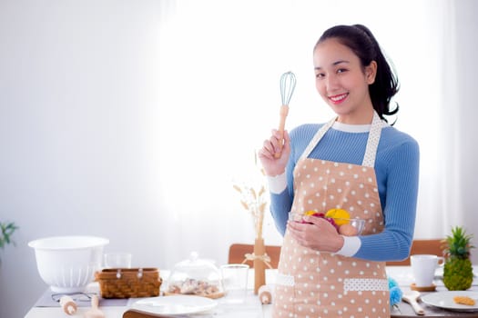 Pretty female holding bowl with a smile in kitchen