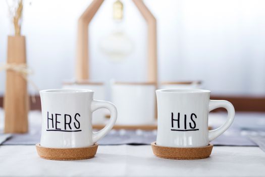 beautiful white cup with his, her text on table.