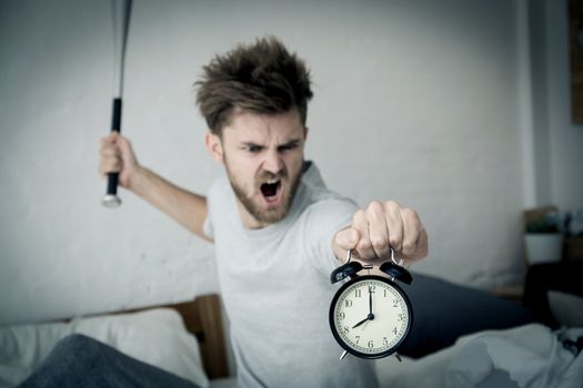 Portrait upset angry with baseball hit young man screaming at alarm clock on bedroom. Employee running late. Time management with business concept