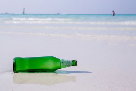 Beer bottle on a sandy beach.