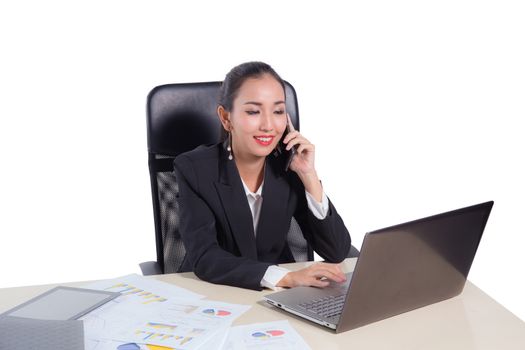 Young businesswoman working in office, typing, using computer and talking phone. Concentrated woman searching information online