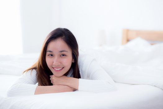 woman beautiful smiling woman portrait wake up early morning after sleeping and lying in bed looking in camera.