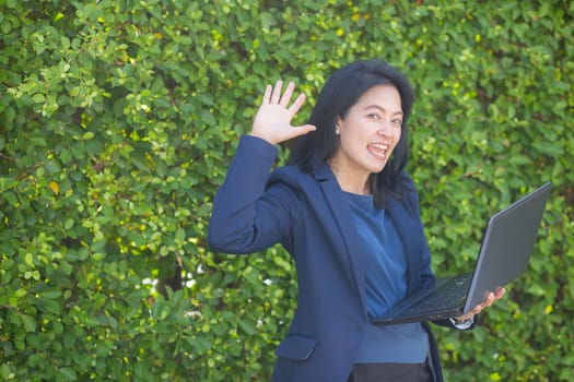 businesswoman holding computer notebook and showing making the glad gesture.