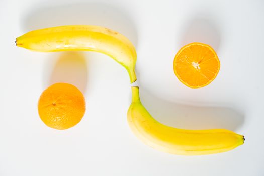 Two oranges and two bananas against a plain white background