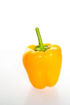 A whole yellow pepper against a plain whit background
